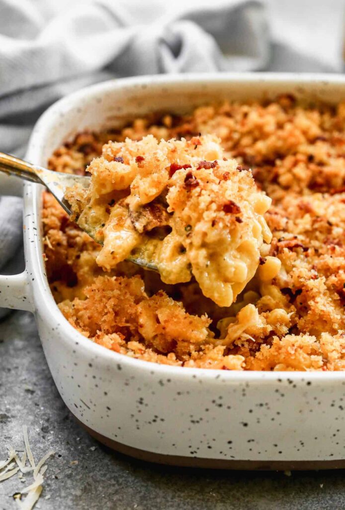 Golden baked mac and cheese with crispy breadcrumb topping served in a white casserole dish
