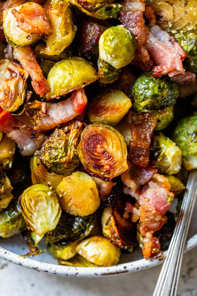 Roasted Brussels sprouts with crispy bacon and maple glaze in a rustic bowl