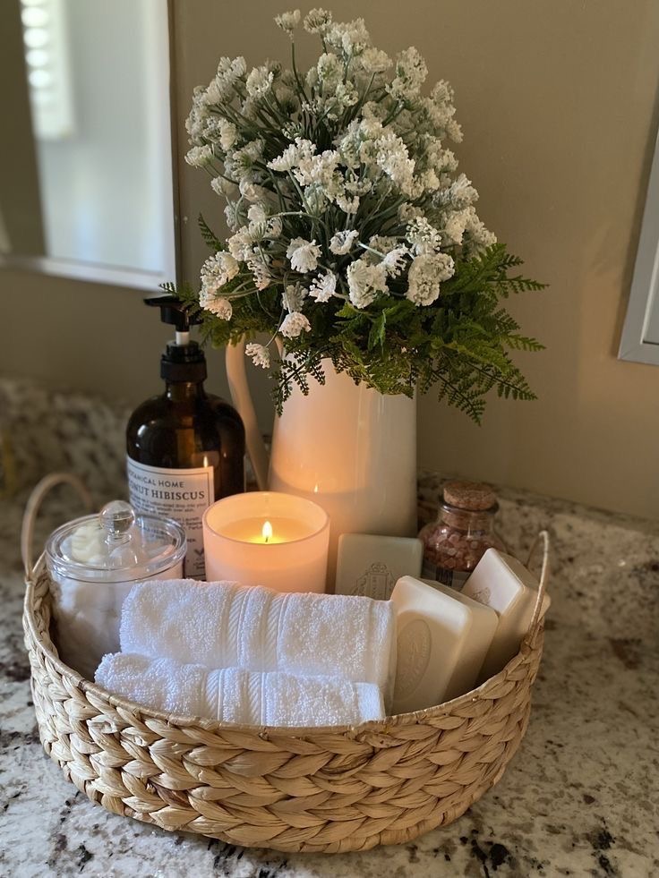 Rolled white hand towels styled neatly in a bathroom counter basket 