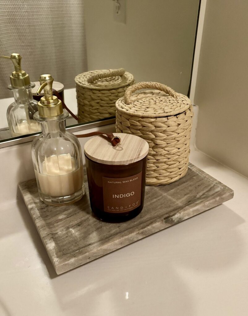 Bathroom counter styled with textured decor including woven and ceramic accents