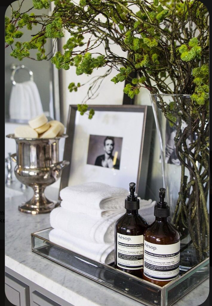 Small framed art leaned against the all on a styled bathroom counter